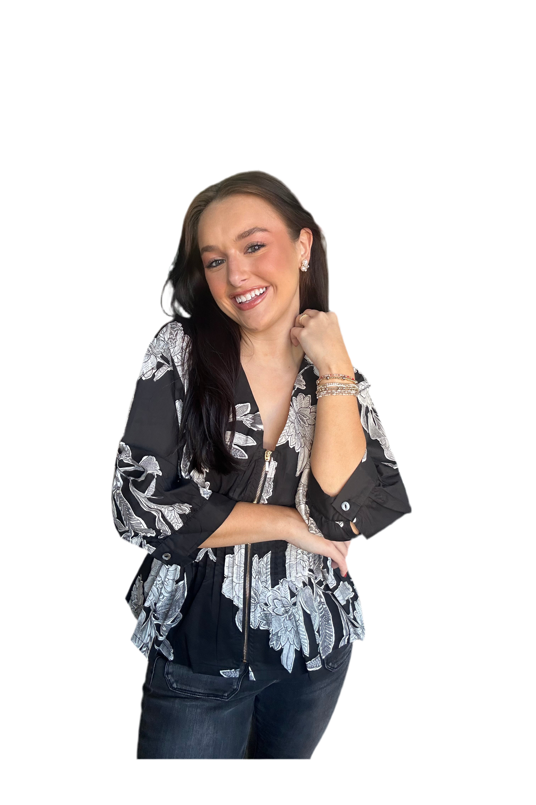Woman wearing a black with white floral zipper blouse. 