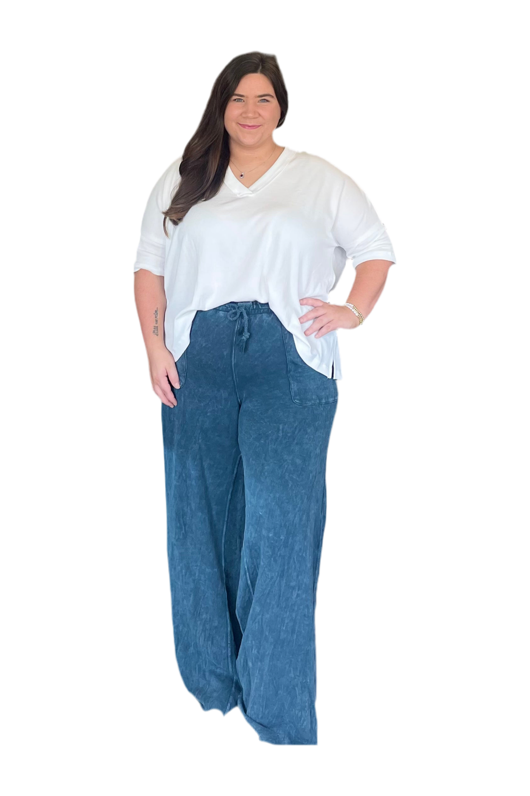 Woman wearing a white top and blue pants on a white background