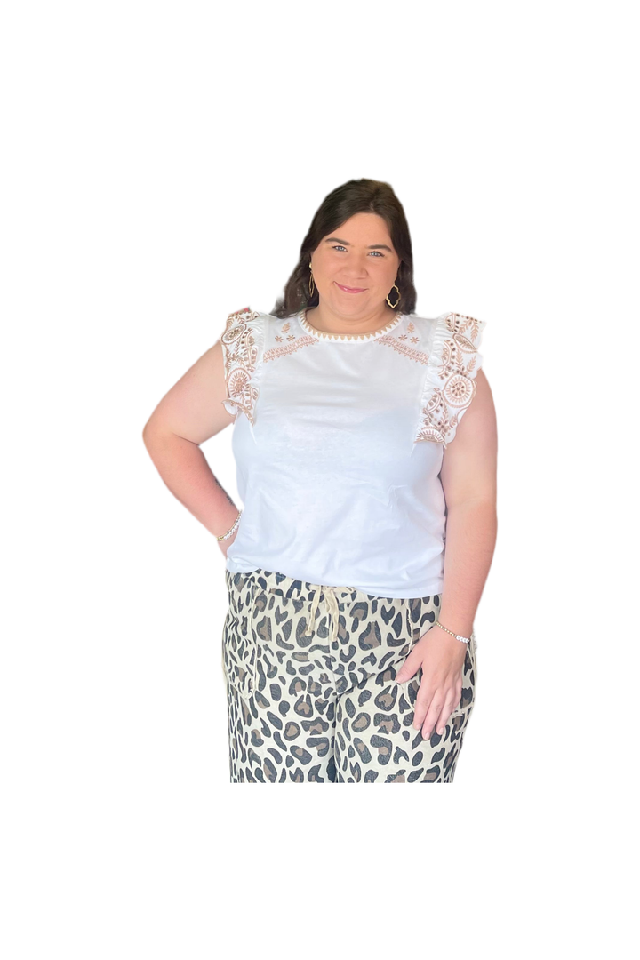 Woman wearing a white lace top and leopard print skirt on a white background