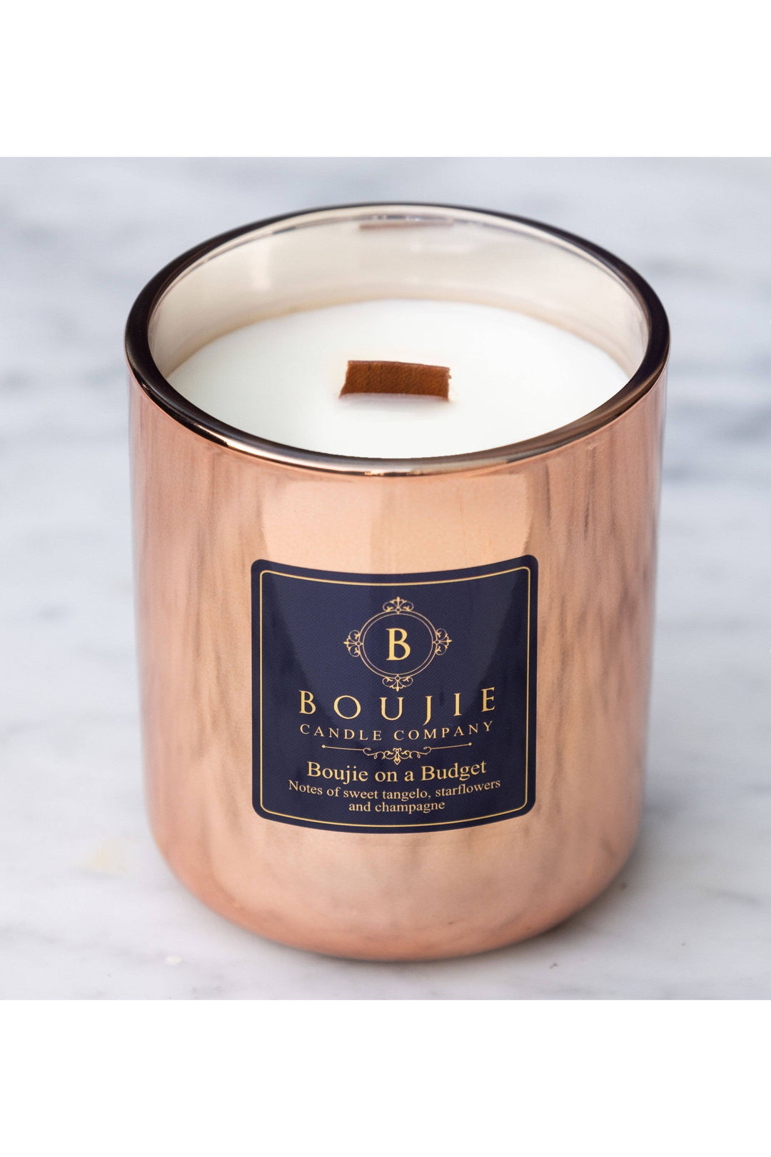 Copper candle with a visible brand label on a light background
