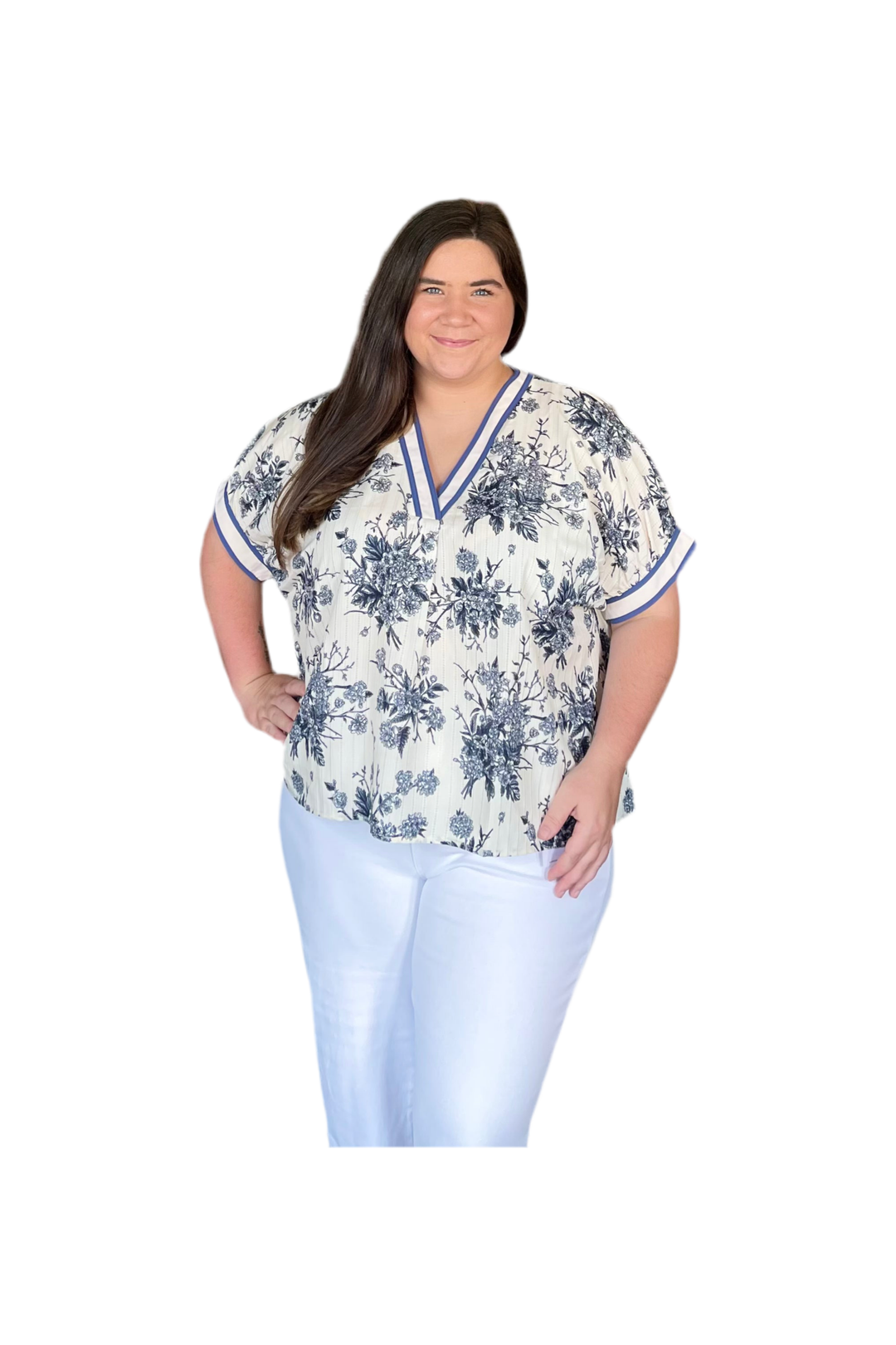 Woman wearing a floral blouse and light blue pants on a white background