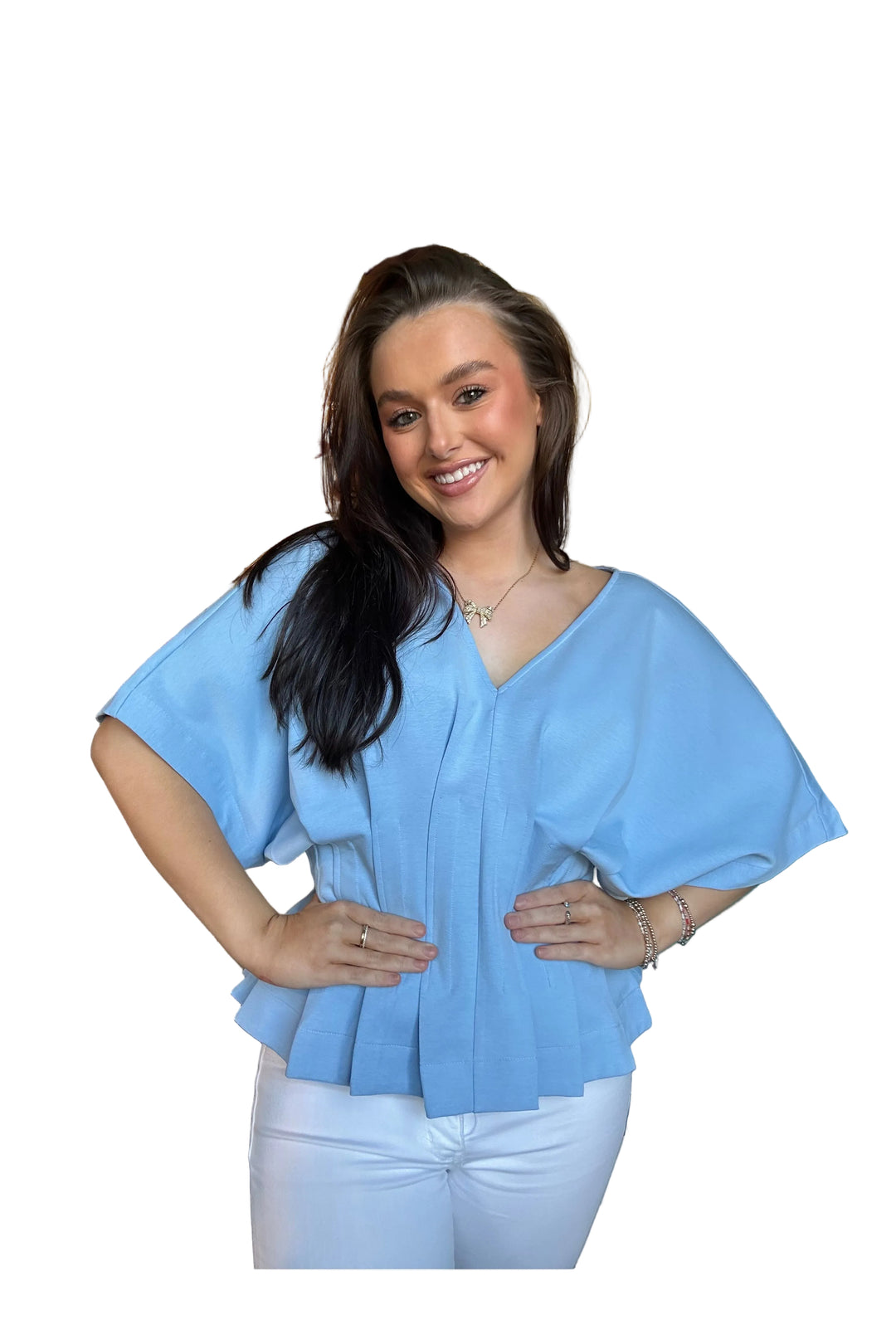 Woman wearing a light blue blouse and white pants on a white background