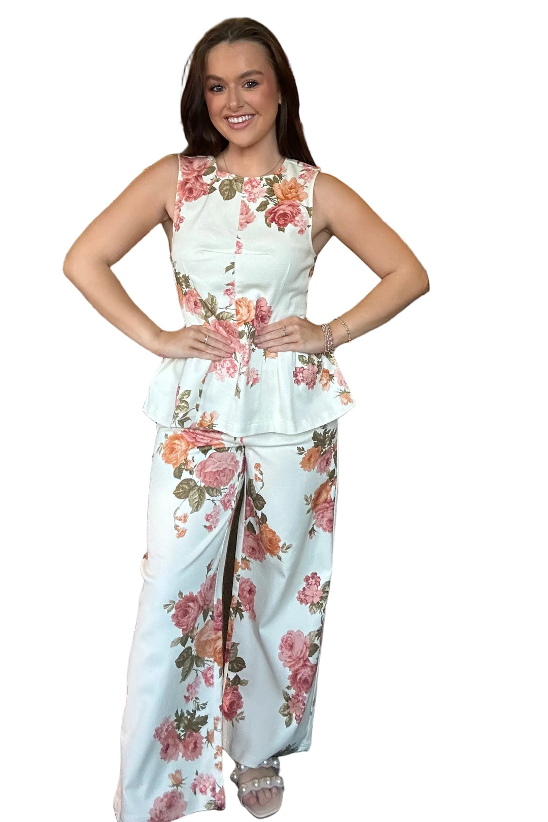 Woman in a floral outfit standing in a clothing store with an open closet.