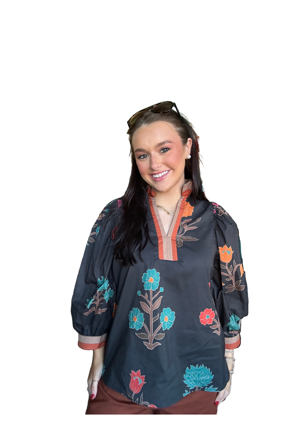 Woman wearing a dark blue embroidered blouse with floral patterns on a white background