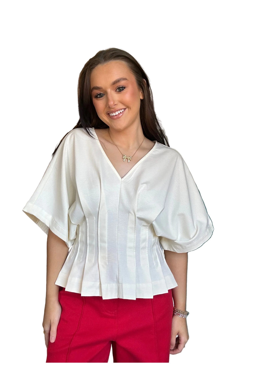 Woman wearing a white blouse and red pants on a white background