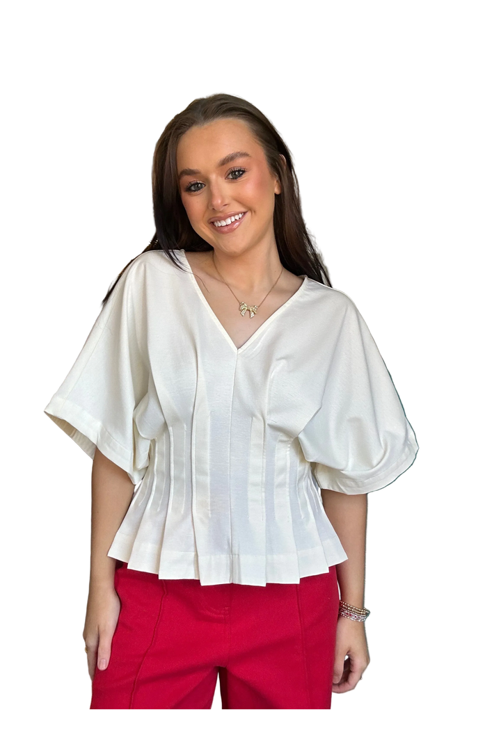 Woman wearing a white blouse and red pants on a white background