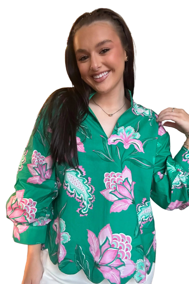Woman wearing a green floral blouse in a clothing store