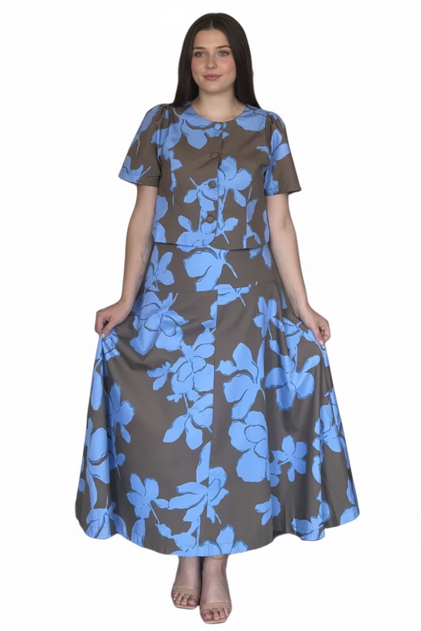 A woman modeling a brown and light blue floral print skirt set with short sleeves cropped top and a buttoned neckline, set against a plain white background.