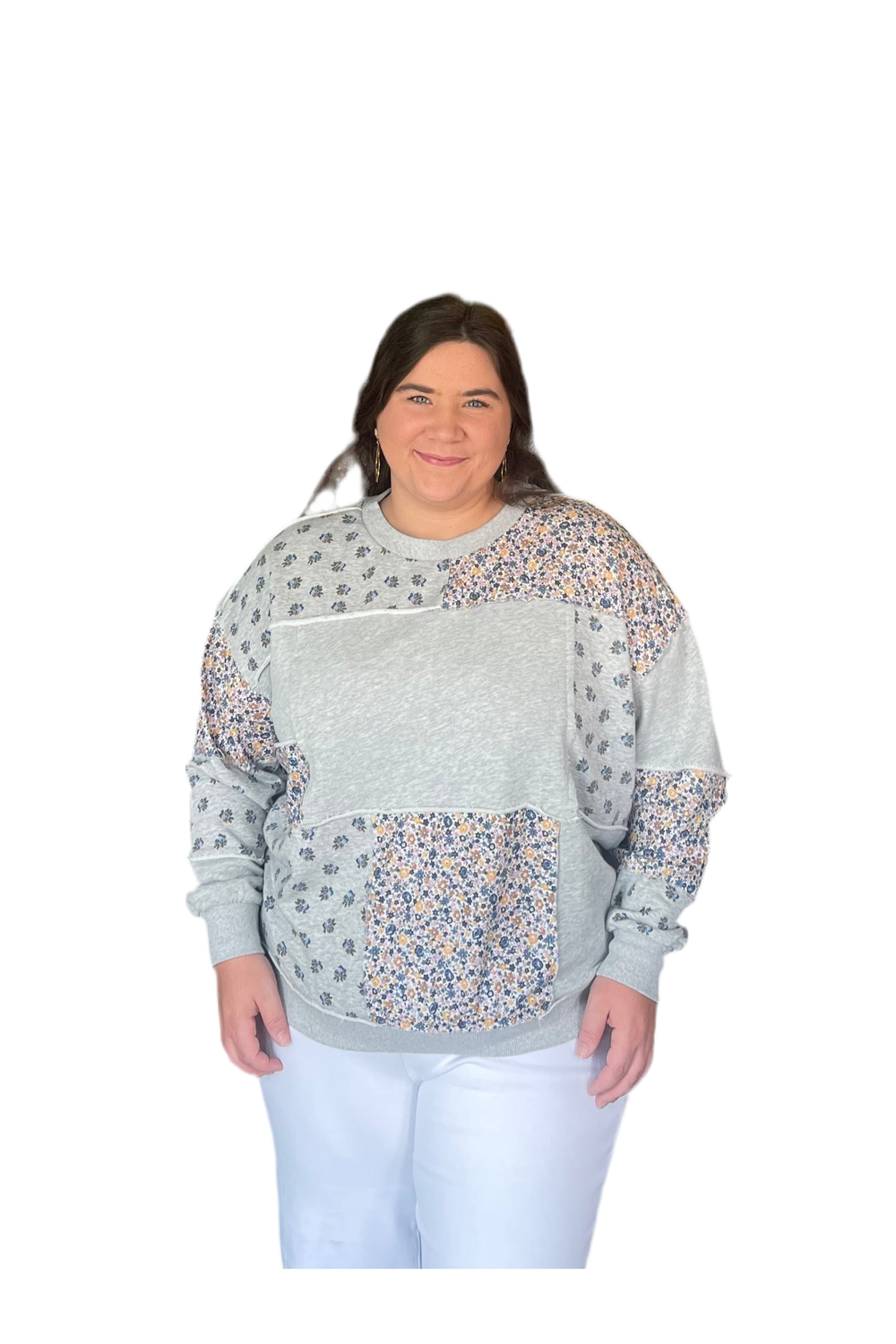 Woman wearing a light gray sweatshirt with floral patterns on a white background