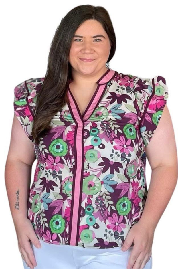 Woman wearing a colorful floral-patterned scrub top on a white background