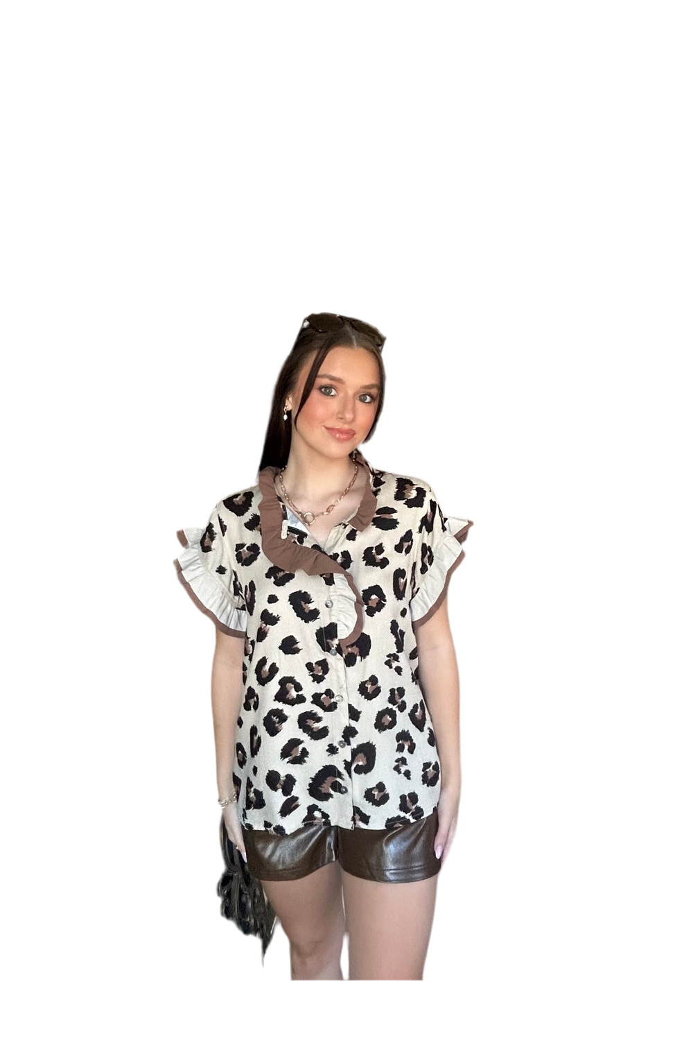 Woman wearing a leopard print top and leather shorts on a white background