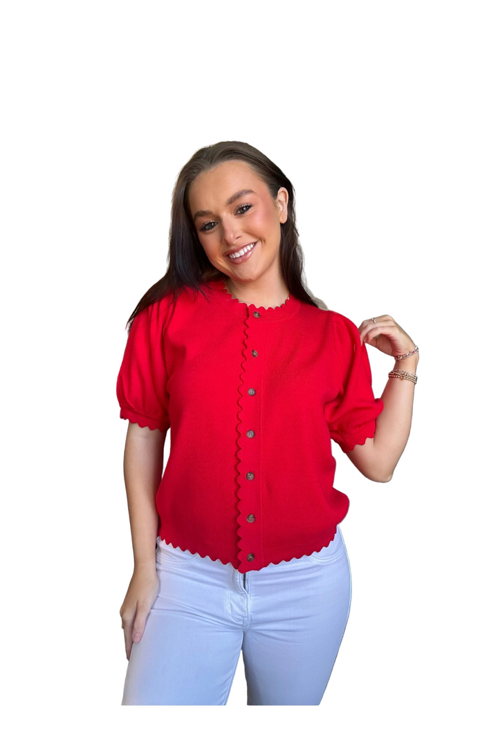 Woman wearing a red blouse with puff sleeves on a white background