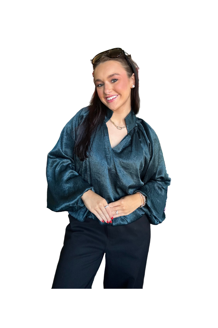 Woman wearing hunter green long sleeve bubble blouse 