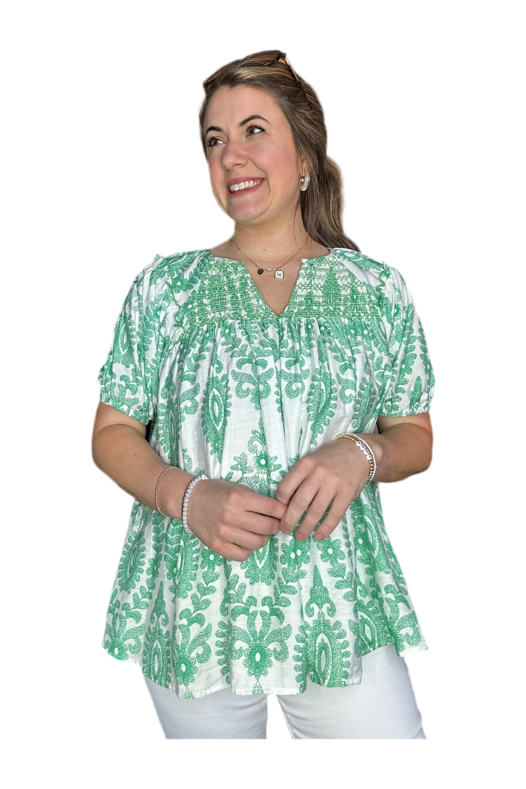 Woman wearing a green and white patterned blouse on a white background