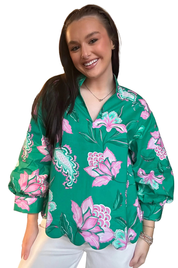 Woman wearing a green floral blouse in a store setting