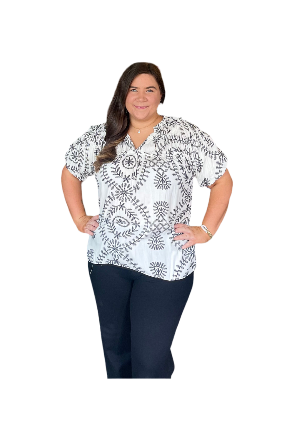 Woman wearing a white blouse with black patterns on a white background