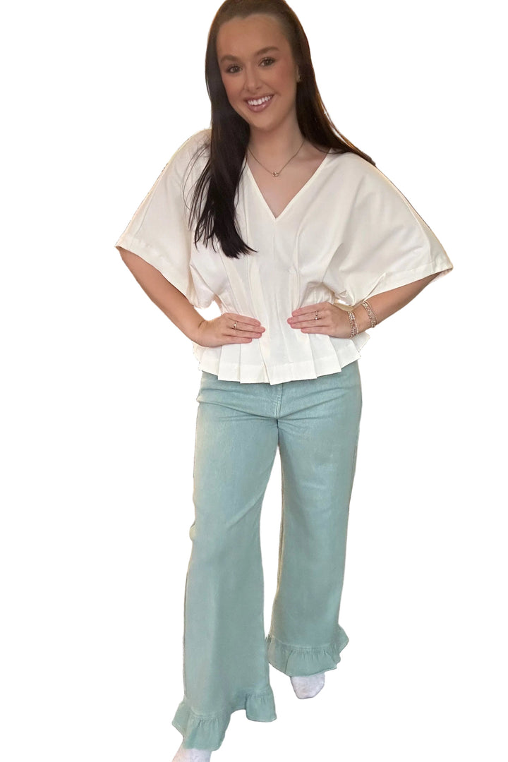 Woman wearing a white blouse and light blue pants in a store setting