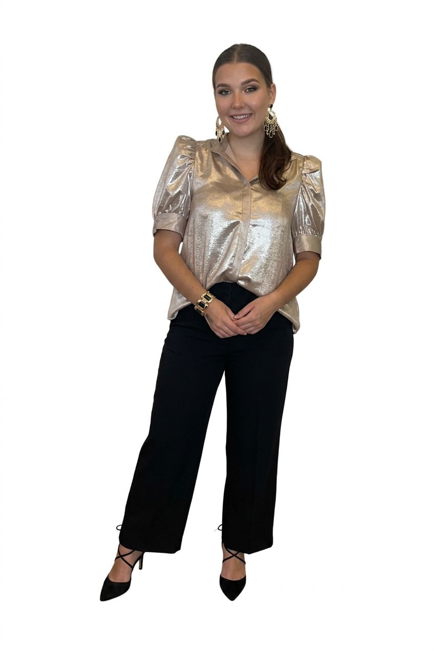 A woman modeling a matching two-piece lounge set consisting of a shiny metallic champagne top with puff sleeves and cream-and-ivory pinstriped pants, standing in front of white curtains.