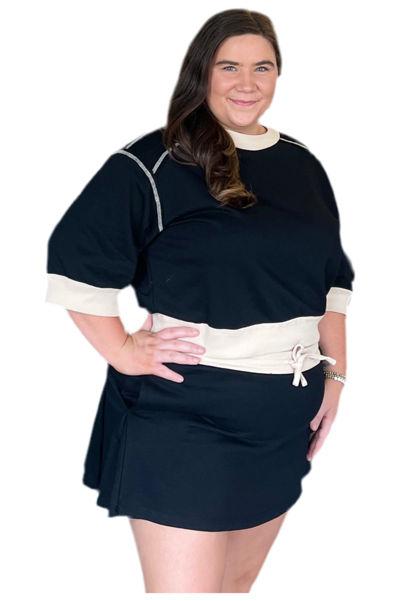 Woman wearing a black dress with white accents on a white background