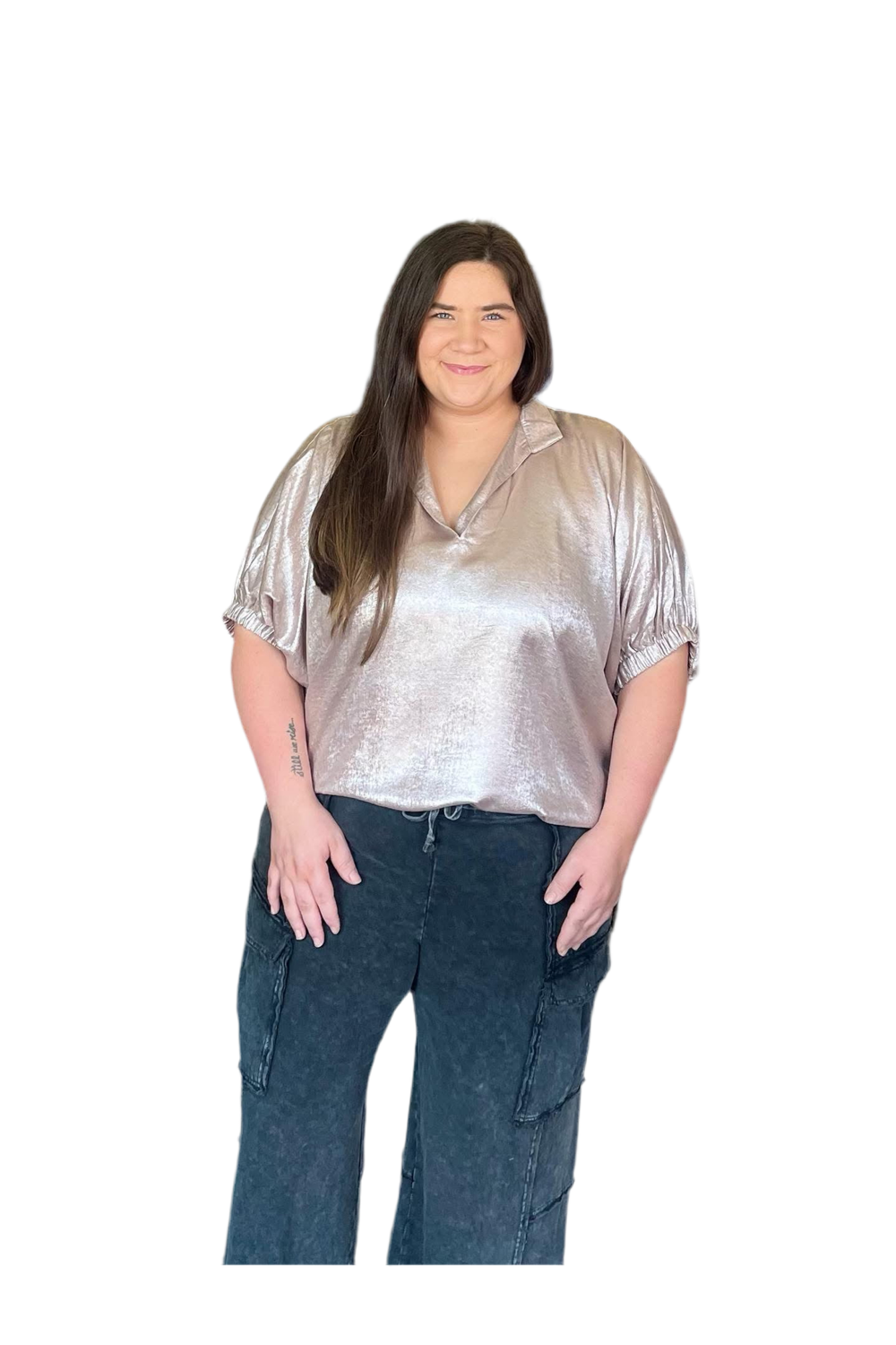 Woman wearing a metallic silver blouse and blue jeans on a white background