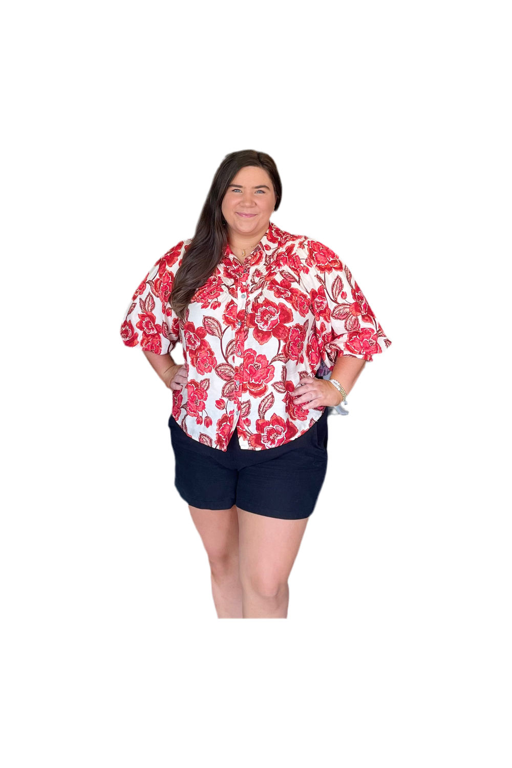 Woman wearing a red and white floral shirt with navy shorts on a white background