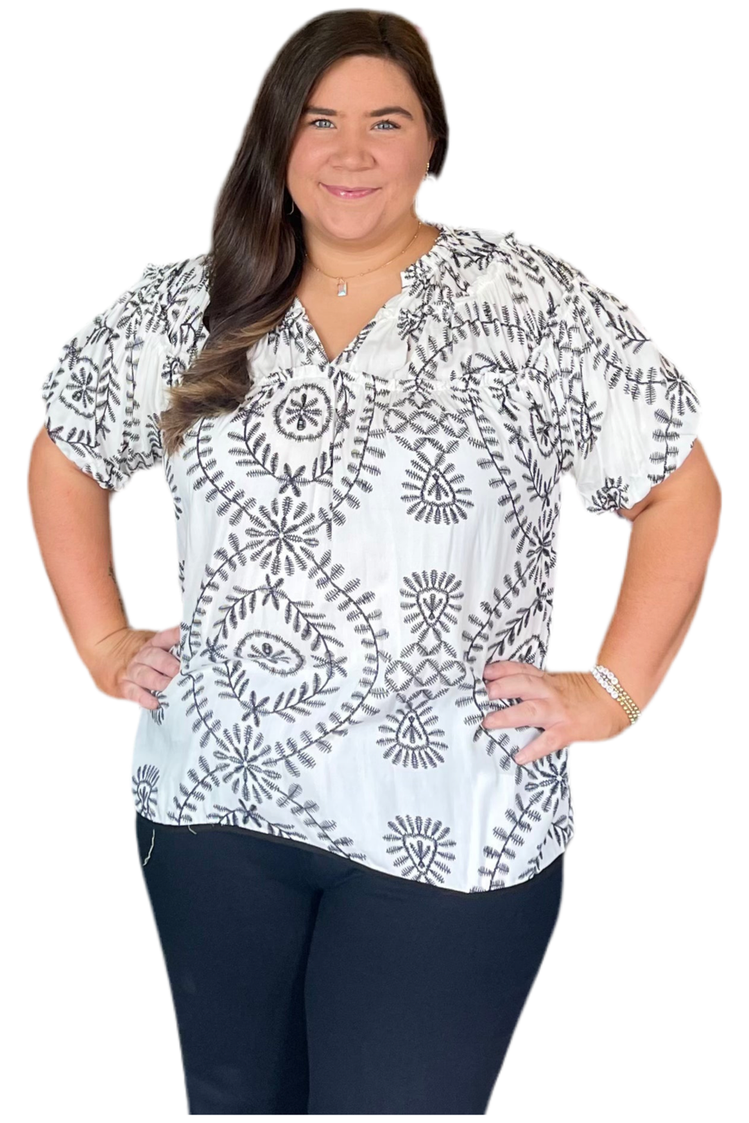 Woman wearing a white blouse with black patterns on a white background