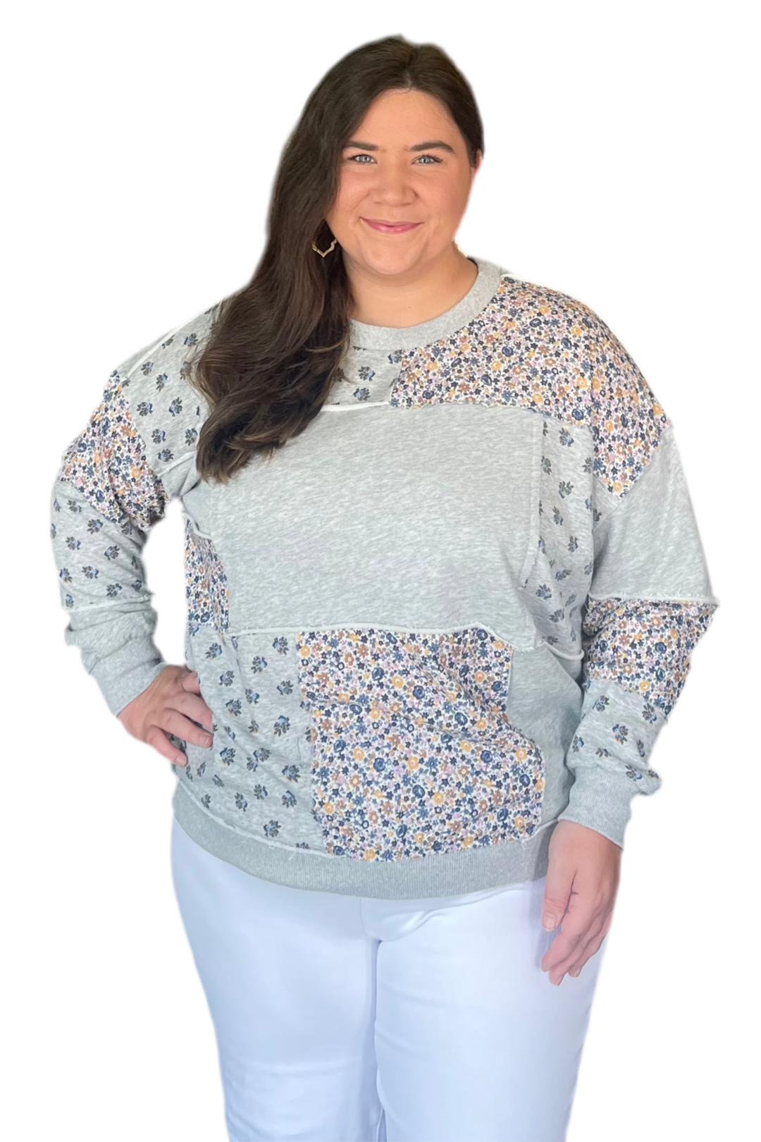 Woman wearing a gray sweater with floral patterns on a white background