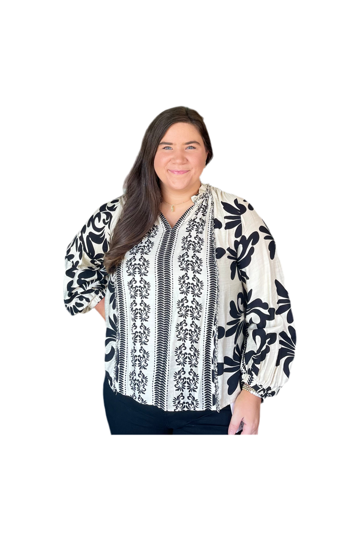 Woman wearing a black and white patterned blouse on a white background