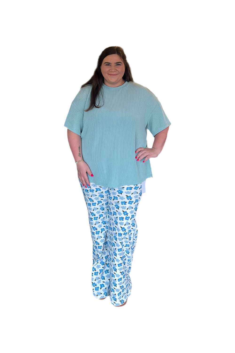 Person wearing a light blue top and patterned pants on a white background