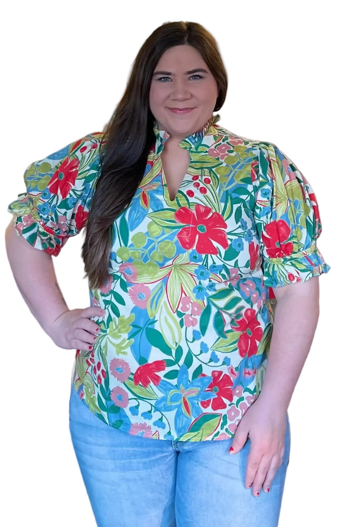 Woman wearing a colorful floral blouse in a store setting