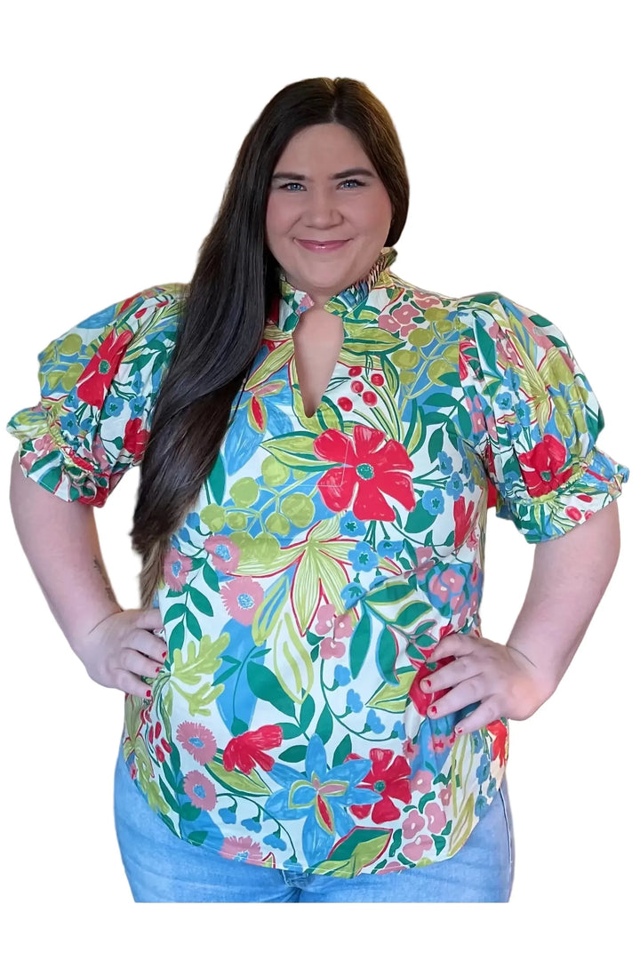 Woman wearing a colorful floral blouse in a store setting