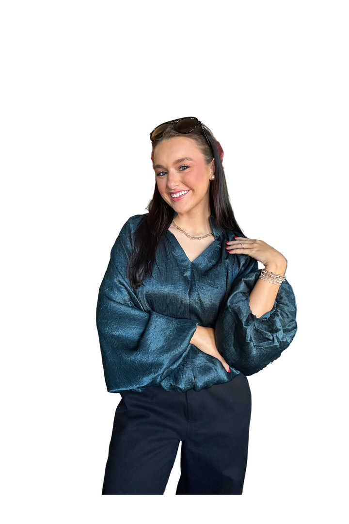 Woman wearing a hunter green long sleeve bubble blouse