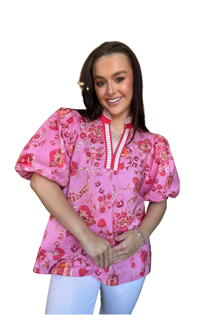 Woman wearing a pink floral blouse with a white background