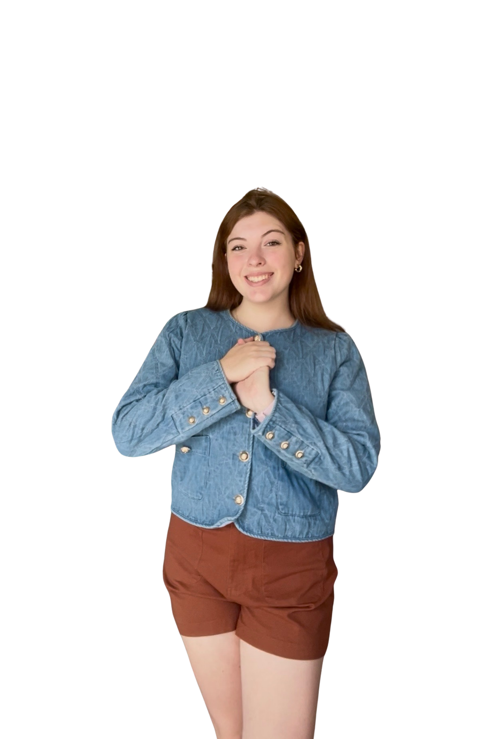 Woman wearing a blue denim jacket and brown shorts on a white background