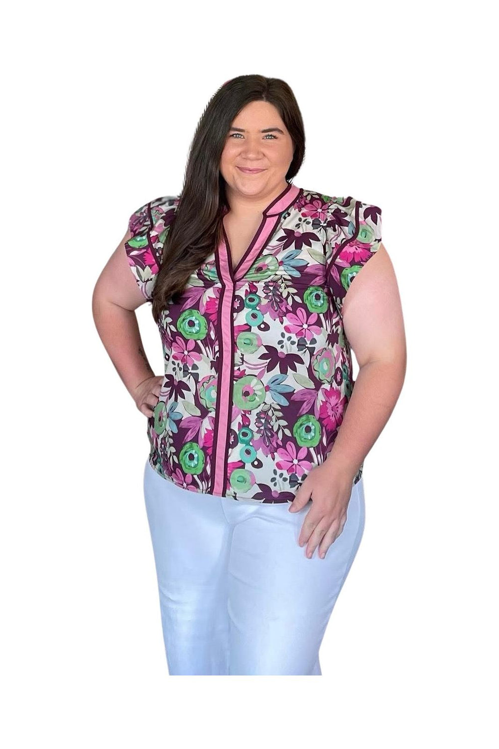 Woman wearing a colorful floral sleeveless top with a white background